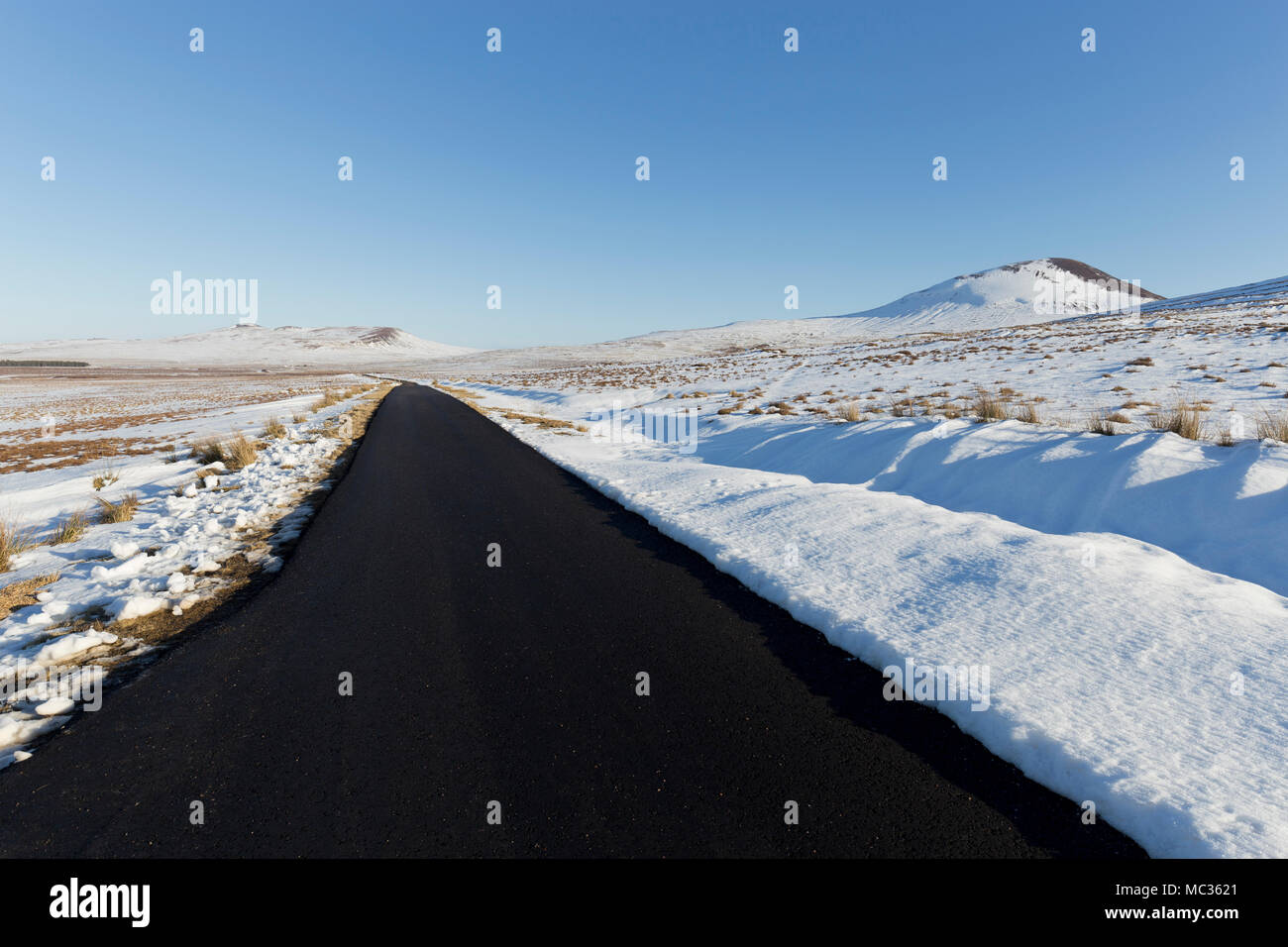 Einsame verschneite Straße in den schottischen Highlands Stockfoto