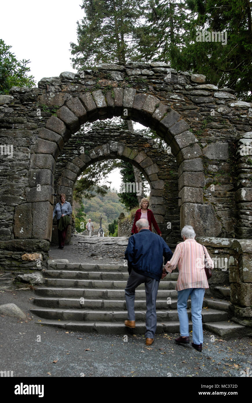Ein hoher mittelalterlicher Torbogen ist der Haupteingang zu einer frühen christlichen Siedlung im Dorf Glendalough, eingebettet in das Tal zweier Seen in der Nähe Stockfoto