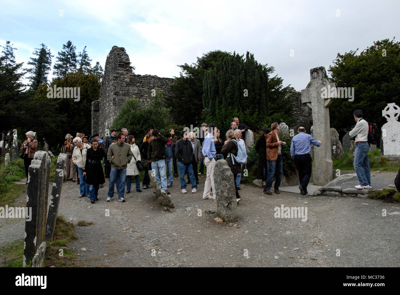 Eine Bustour, die die Wunder der Kathedralenruinen in einer frühen christlichen Siedlung im Dorf Glendalough, eingebettet in das Tal, erkundet Stockfoto