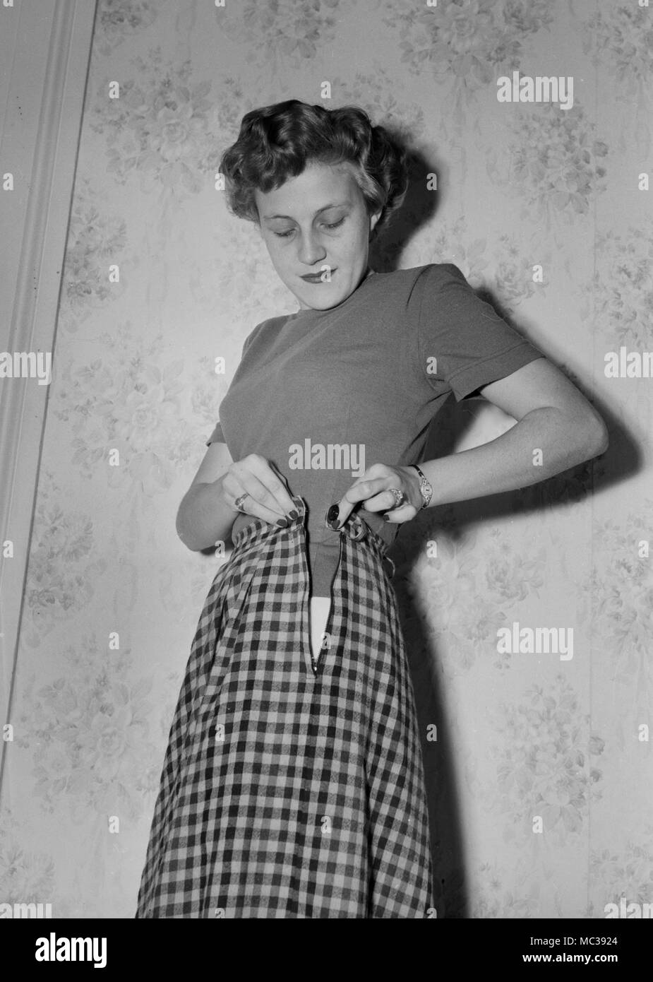Eine Frau, die mit ihrem Rock geprüft, Ca. 1958. Stockfoto