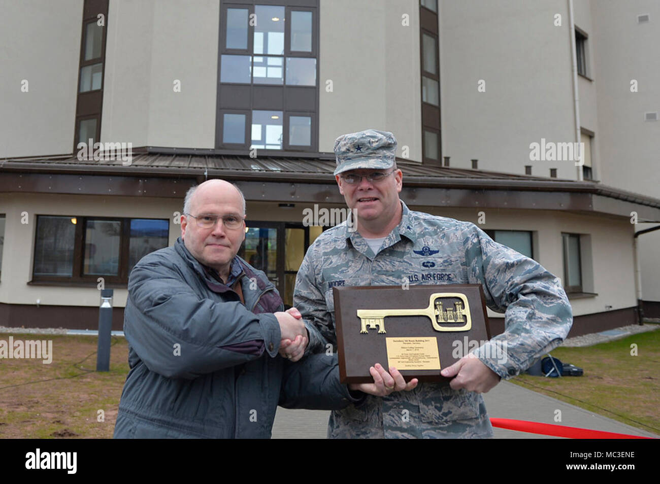 Us Air Force Brig. Gen. Richard G. Moore jr., 86th Airlift Wing Commander, rechts, erhält eine Plakette, Schlüssel von Dave Nichols von der US-Armee Korps der Ingenieure bei einem Ribbon Cutting auf der Air Base Ramstein, Deutschland, 7. März 2017. Das Bauvorhaben für Schlafsaal 2411 sah die Beteiligung vom 86. CES, Luftwaffe Bauingenieur Center, US-Armee Korps der Ingenieure, und Kaiserslautern, Bau Agentur. Stockfoto