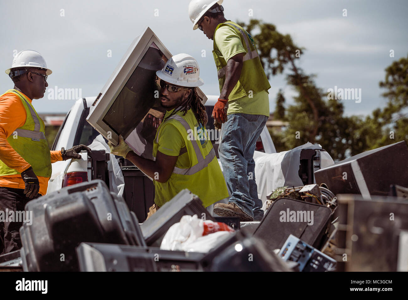 SANTA ISABEL, Puerto Rico, 12. Februar 2018 - Mitglieder der Environmental Protection Agency (EPA) entladen und gefährliche Abfälle kategorisieren ordnungsgemäß an der nächstgelegenen Sammelstelle zu entsorgen. In Zusammenarbeit mit der FEMA, das EPA hat die Aufgabe der Sammlung und ordnungsgemäße Entsorgung Haushalt gefährliche Abfälle (HHW) und Elektronik während der Hurrikan Maria Antwort in Puerto Rico. Stockfoto