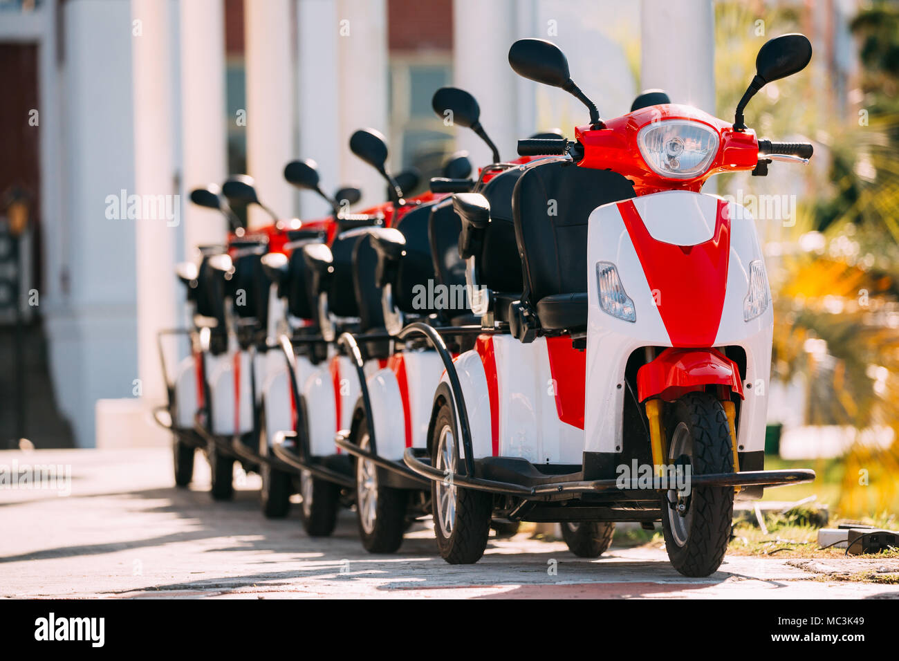 Viele Vermietung elektrische Motorräder, Motorräder Motorroller geparkt In der Zeile in der Straße der Stadt. Stockfoto