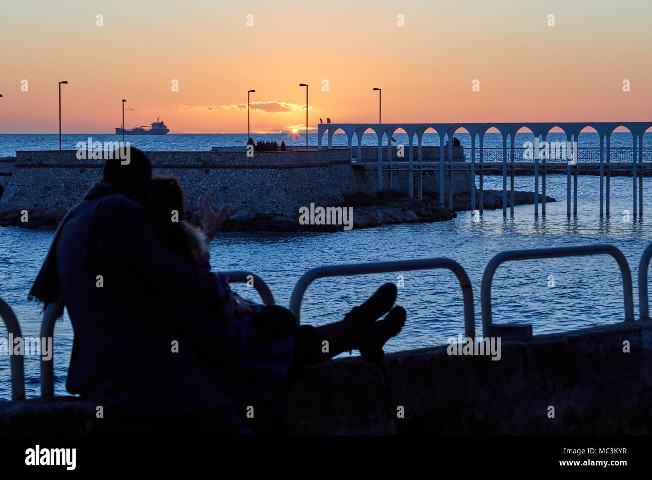 Romantisches Paar beobachten Sie den Sonnenuntergang zusammen in einem Winter am Nachmittag Stockfoto