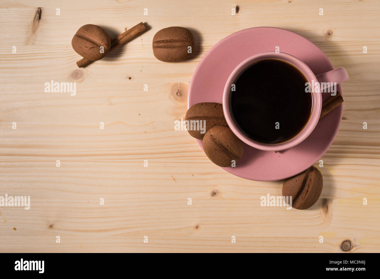 Kaffee am Morgen in einem rosa Tasse mit Kaffeebohnen Form cookies Stockfoto