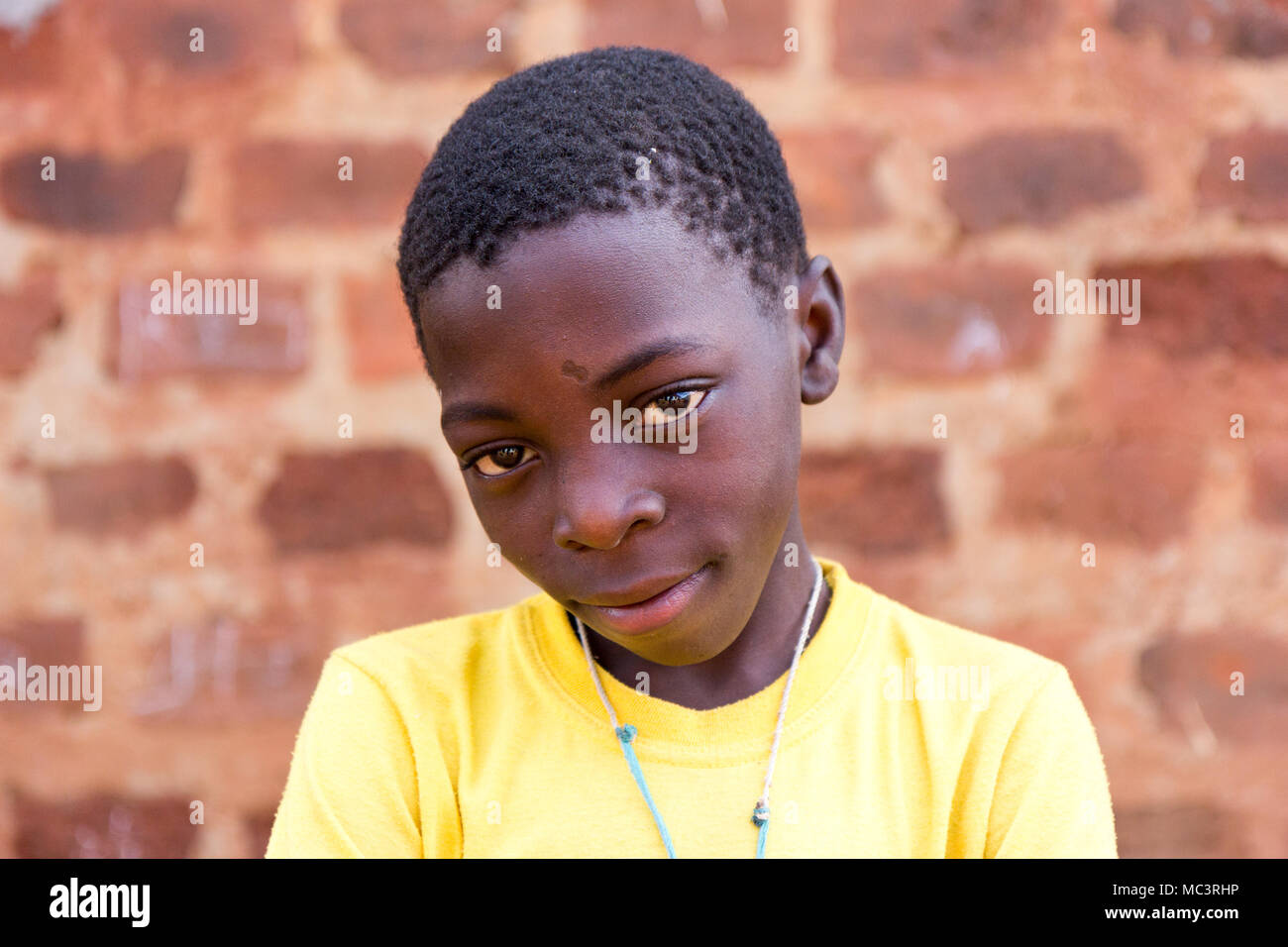 Uganda. 13. Juni 2017. Eine ugandische Junge mit Waffen in der Grundschule gekreuzt. Stockfoto