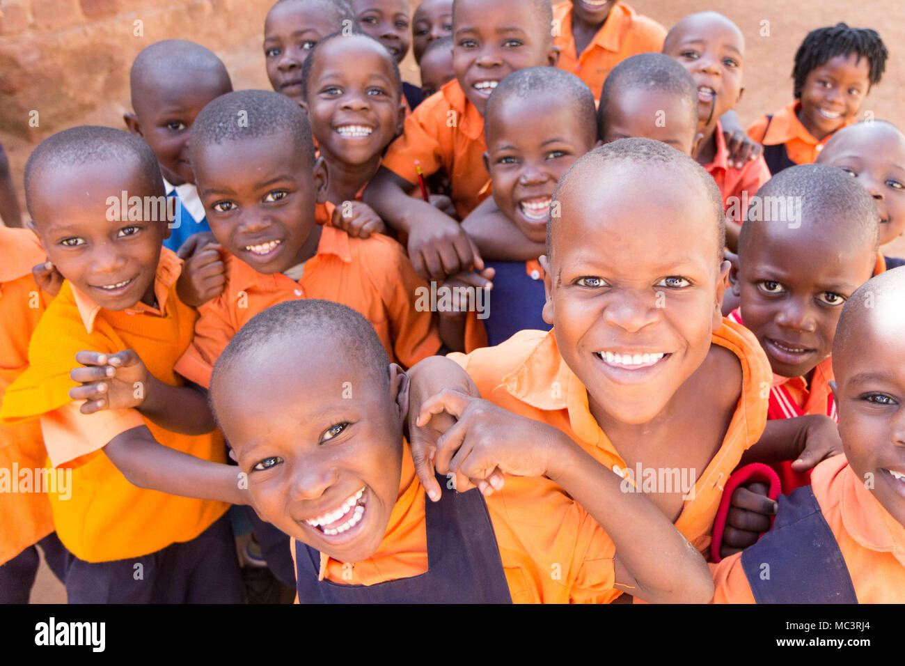 Uganda. 13. Juni 2017. Eine Gruppe von Happy Grundschulkinder lächeln, lachen und winken an einer Grundschule. Stockfoto