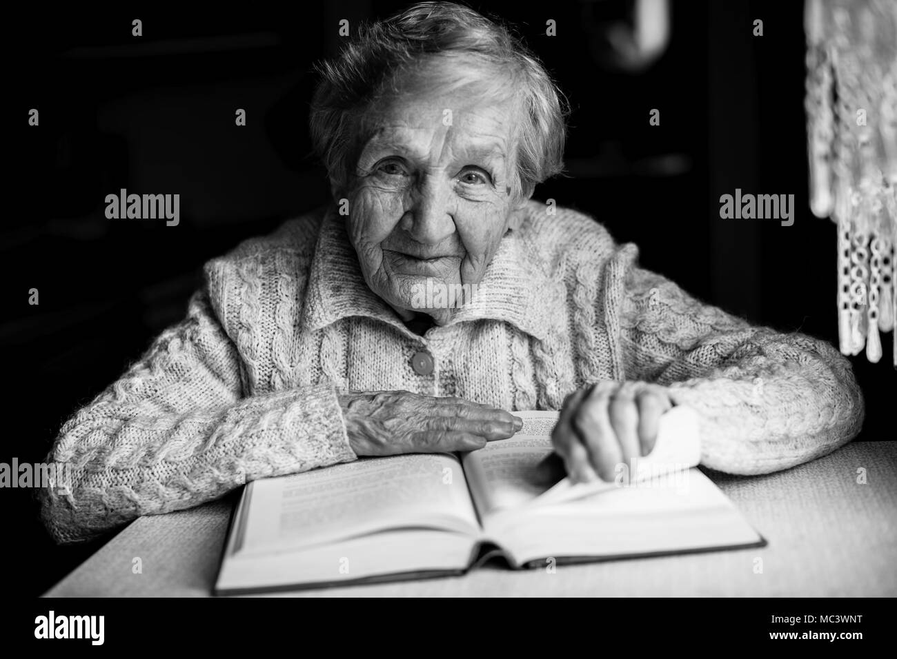 Großmutter lesen Bücher sitzen am Tisch. Stockfoto