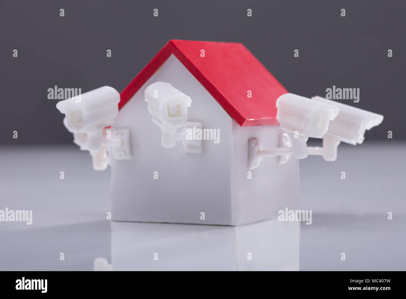 In der Nähe von Haus Modell mit Überwachungskamera auf reflektierenden Hintergrund Stockfoto