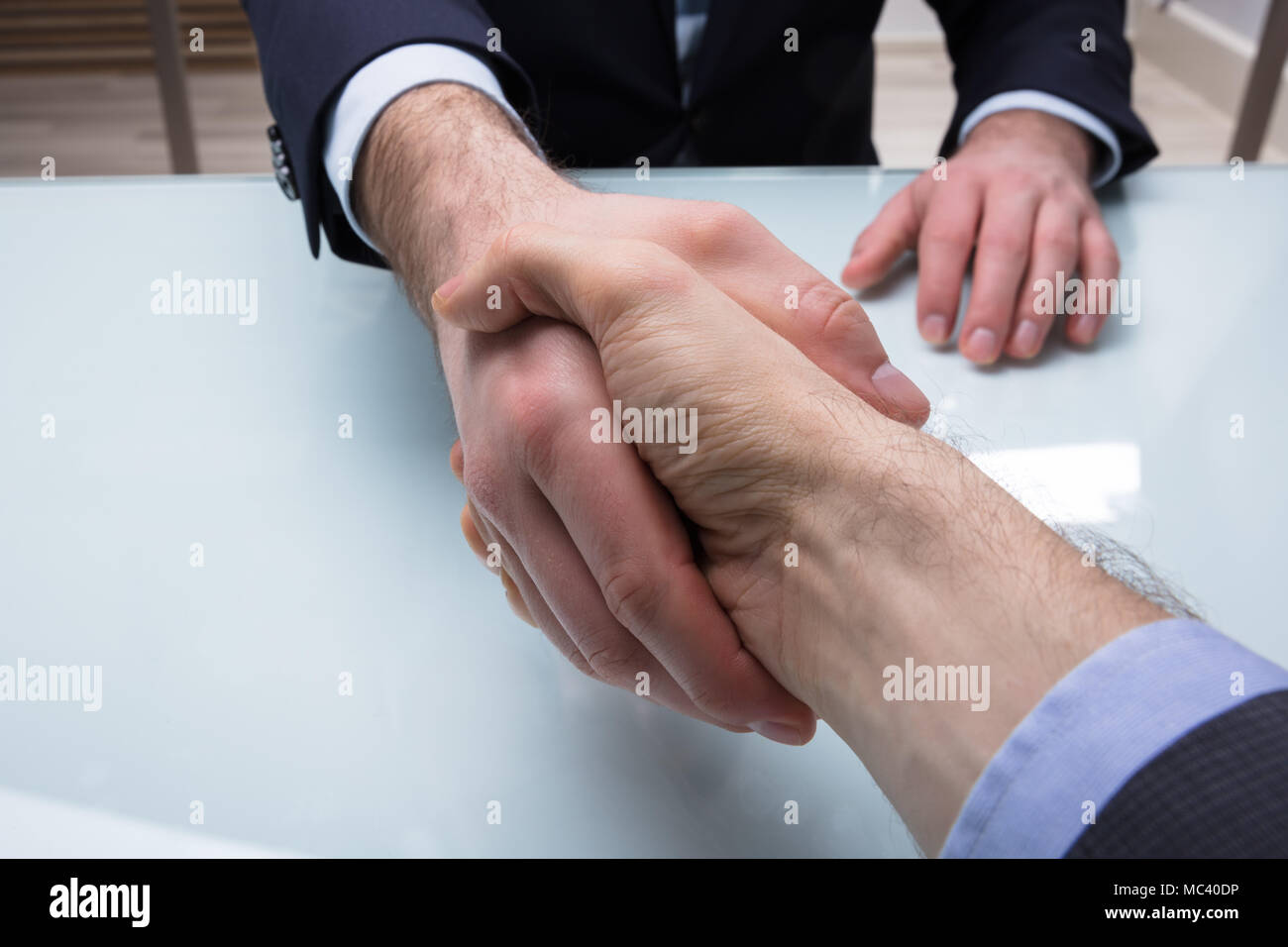Nahaufnahme eines Geschäftsmannes zitternden Hand mit seinem Partner im Büro Stockfoto