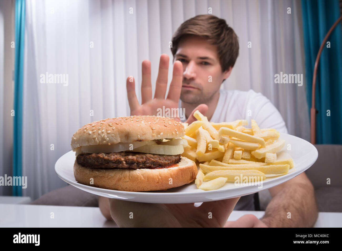 Mann weigert Ungesunde Lebensmittel angeboten, die von einer Person Stockfoto