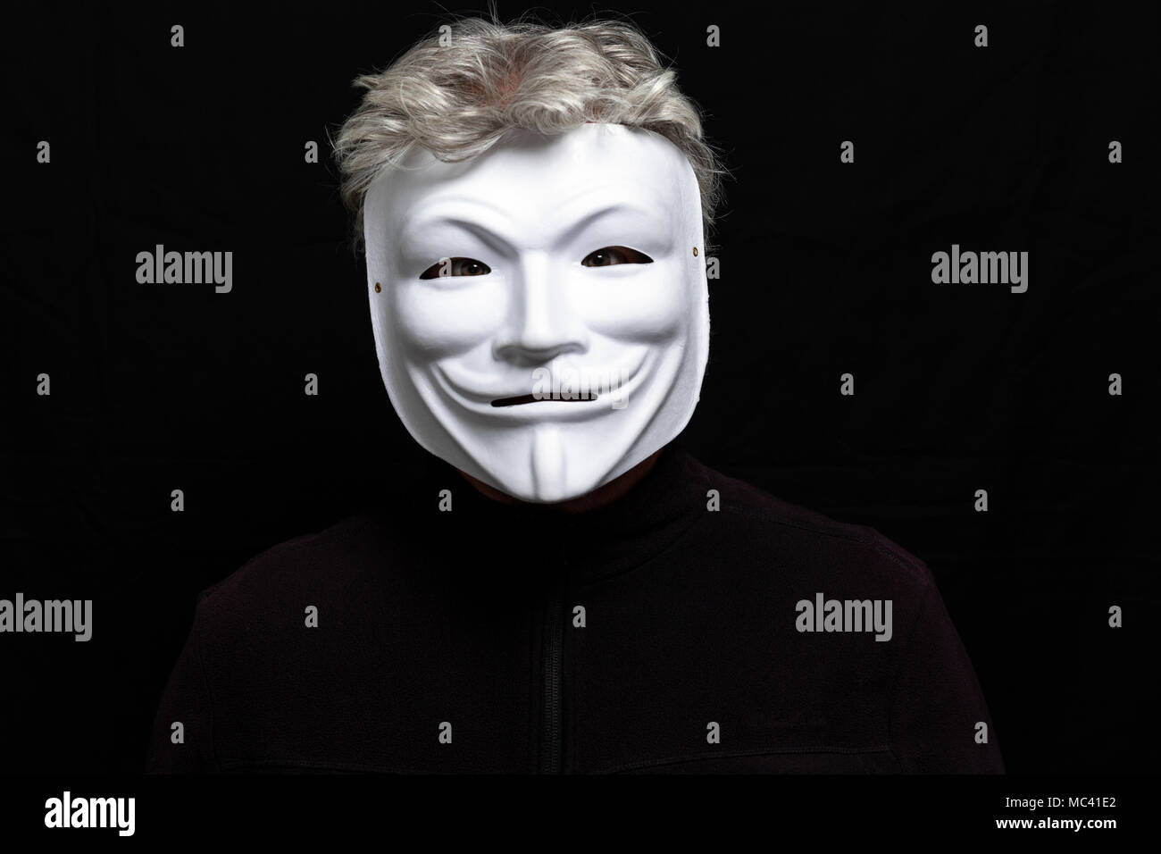 Grauhaariger Mann in anonymen Maske Stockfoto