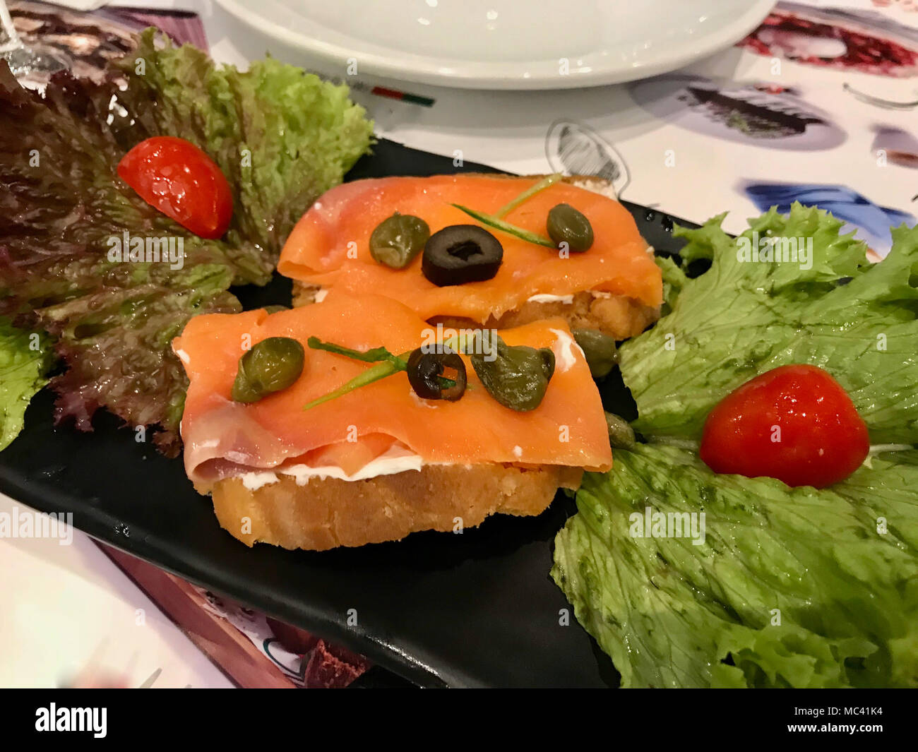 Geräucherter Lachs und Frischkäse auf knuspriges Brot als Vorspeise essen. Stockfoto