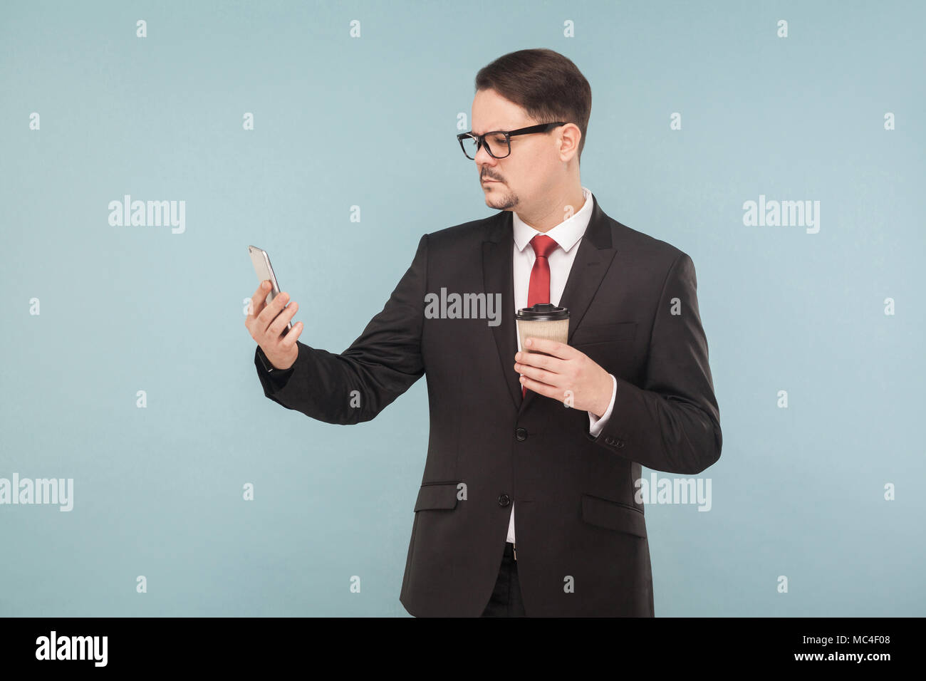 Business Mann testen neue Telefon- und Face-Id. Zukünftige Technologien. Innen-, Studio shot, von blauen oder grauen Hintergrund isoliert Stockfoto