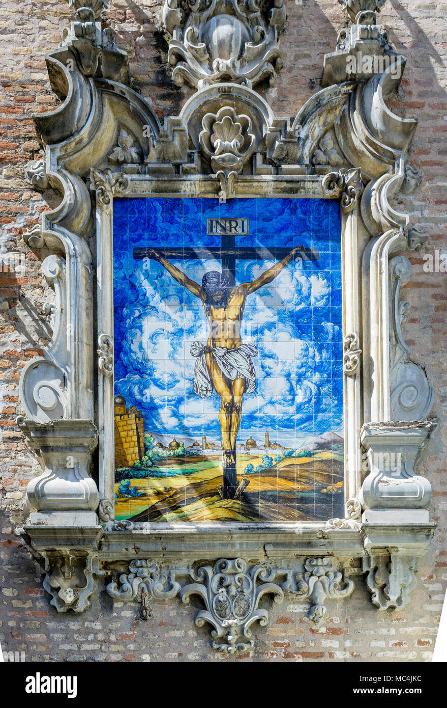 Keramische Fliesen, die Jesus Christus am Kreuz außerhalb der Verkündigungskirche (Iglesia de la Anunciacion) in der spanischen Stadt Sevilla, Spanien Stockfoto