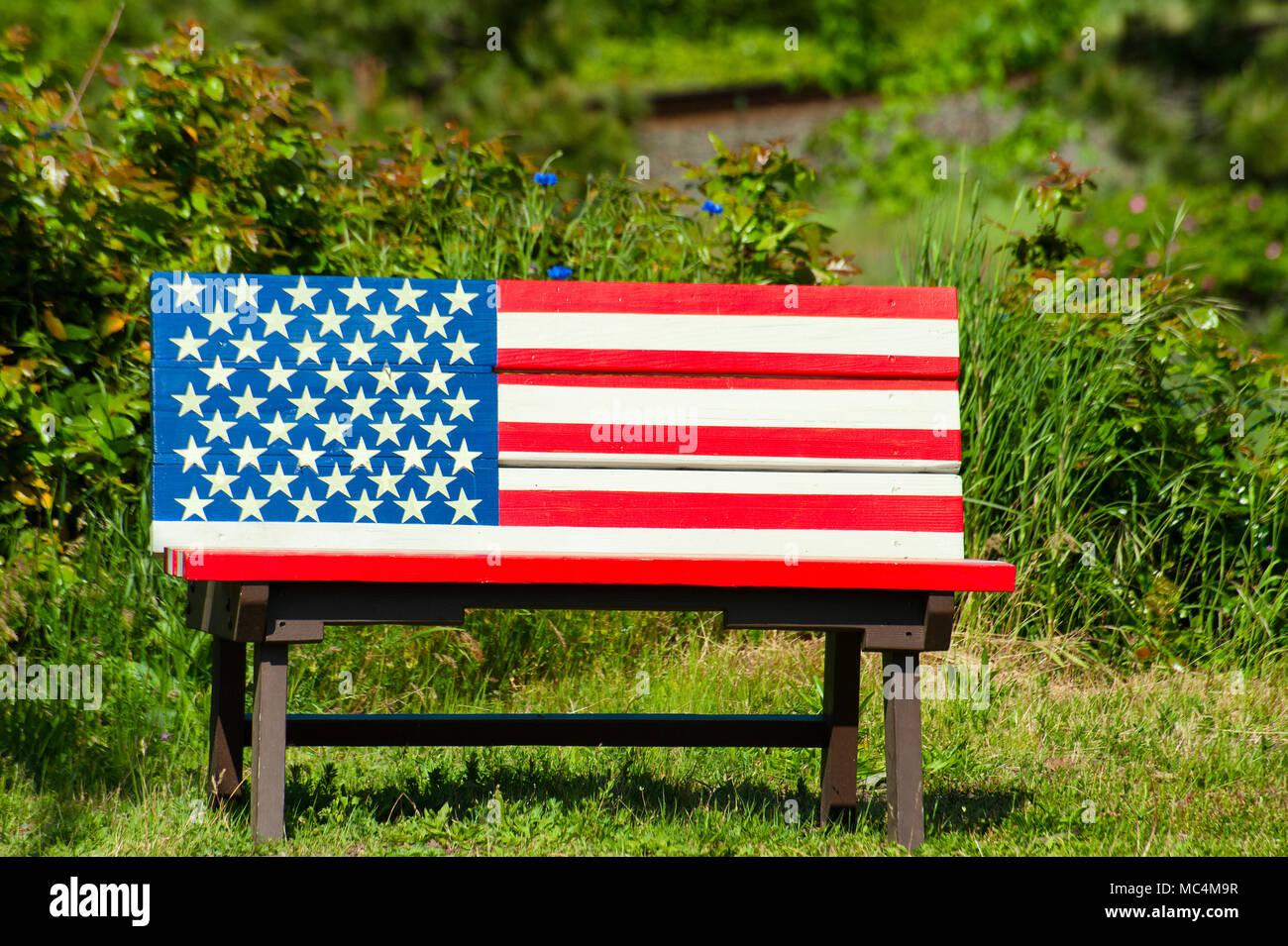 Eine Bank mit der amerikanischen Flagge bemalt. Stockfoto