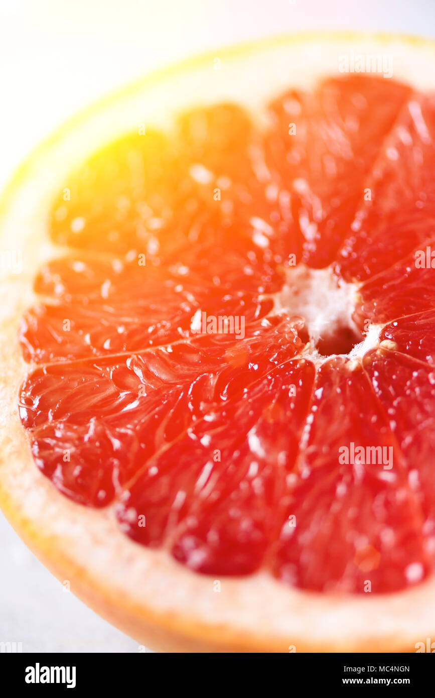 Grapefruit in Scheiben geschnittene Hälfte auf grauem Hintergrund. Zitrusfrüchte Makro. Platz kopieren, Ansicht von oben. Sommer essen Konzept Stockfoto