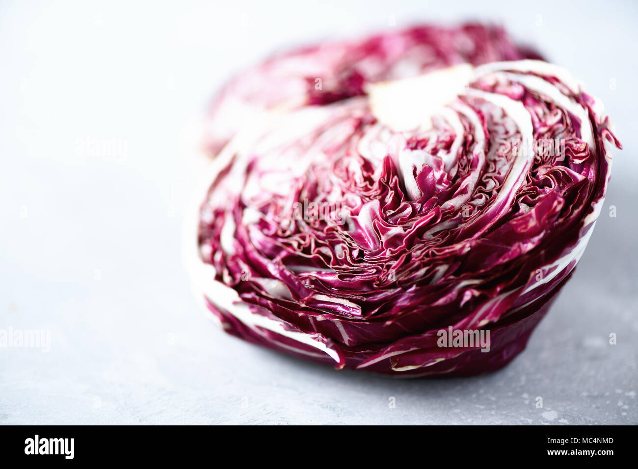Radicchio, purpur violett Salat auf grauem Beton Hintergrund. Platz kopieren, aus der Nähe. Raw, vegan, vegetarisch Konzept Stockfoto