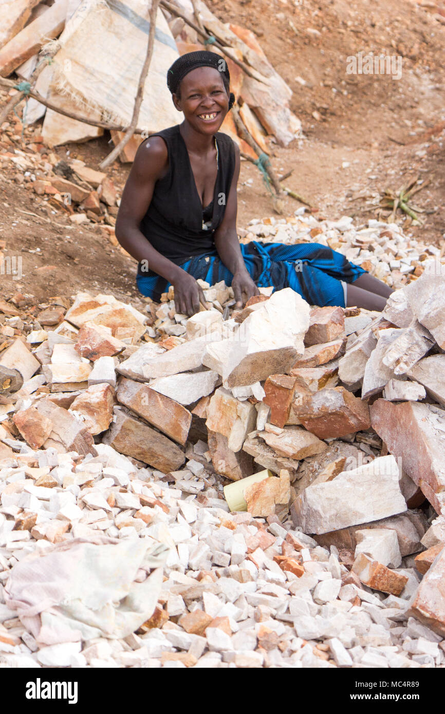 Lugazi, Uganda. 18. Juni 2017. Eine ugandische Frau brechen Steine in kleine Platten für ihren Meister. Stockfoto