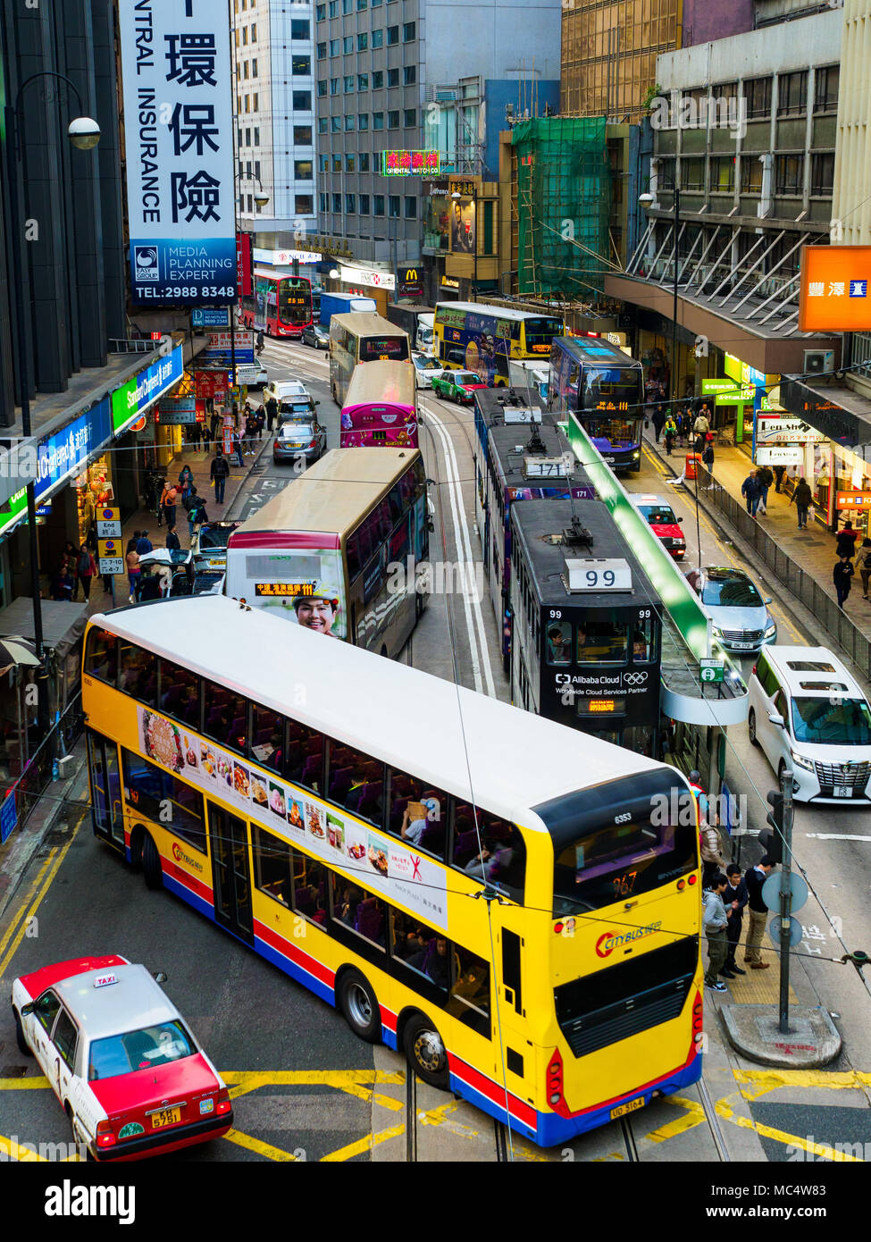 Verkehrsüberlastung in Hongkong - Busse Straßenbahnen und Taxis mischen sich im Zentrum Hongkongs. Stockfoto
