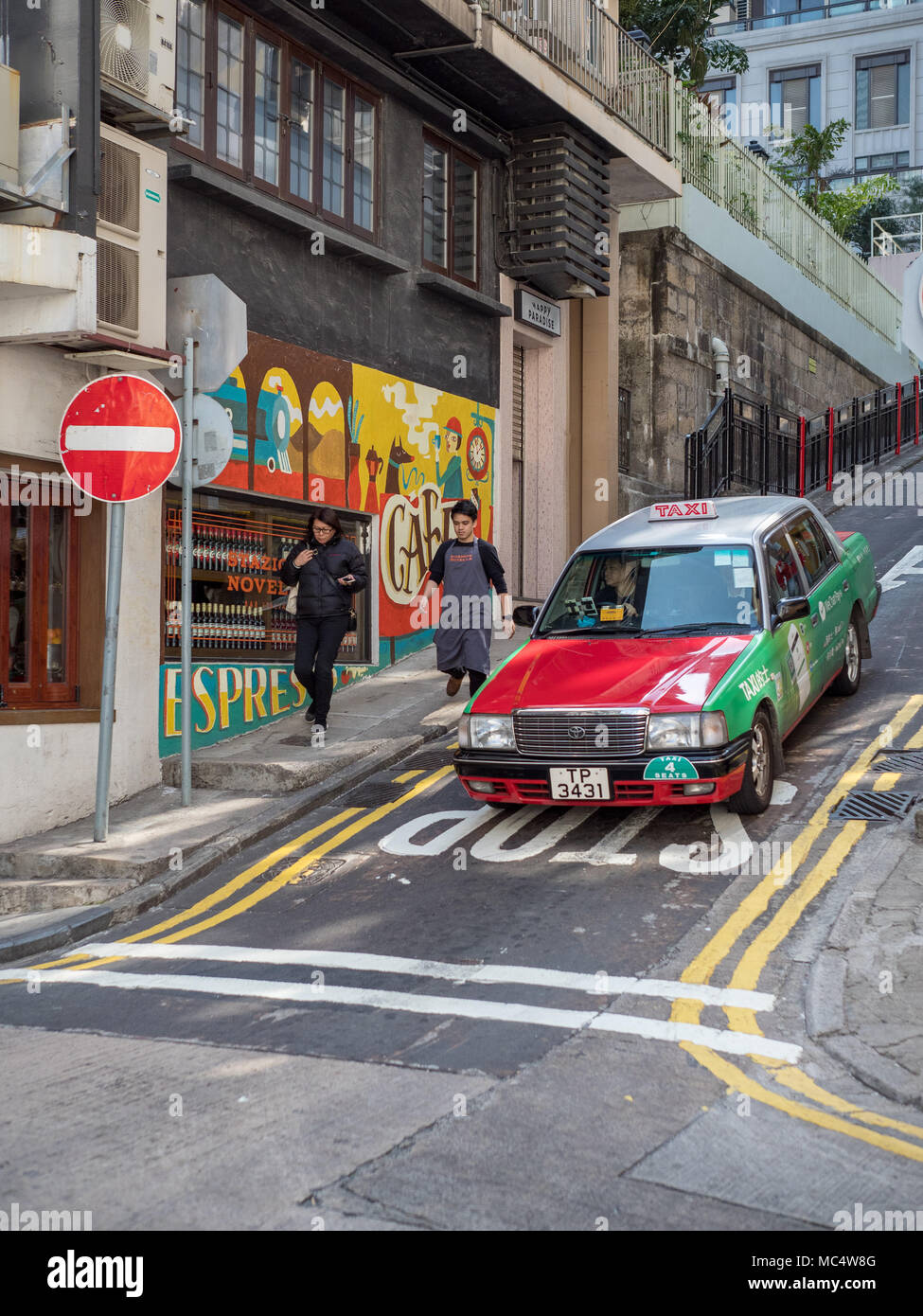 Hong Kong Taxi Cab verhandelt über eine steile Straße im Mid-Level-Bereich der Stadt. Stockfoto