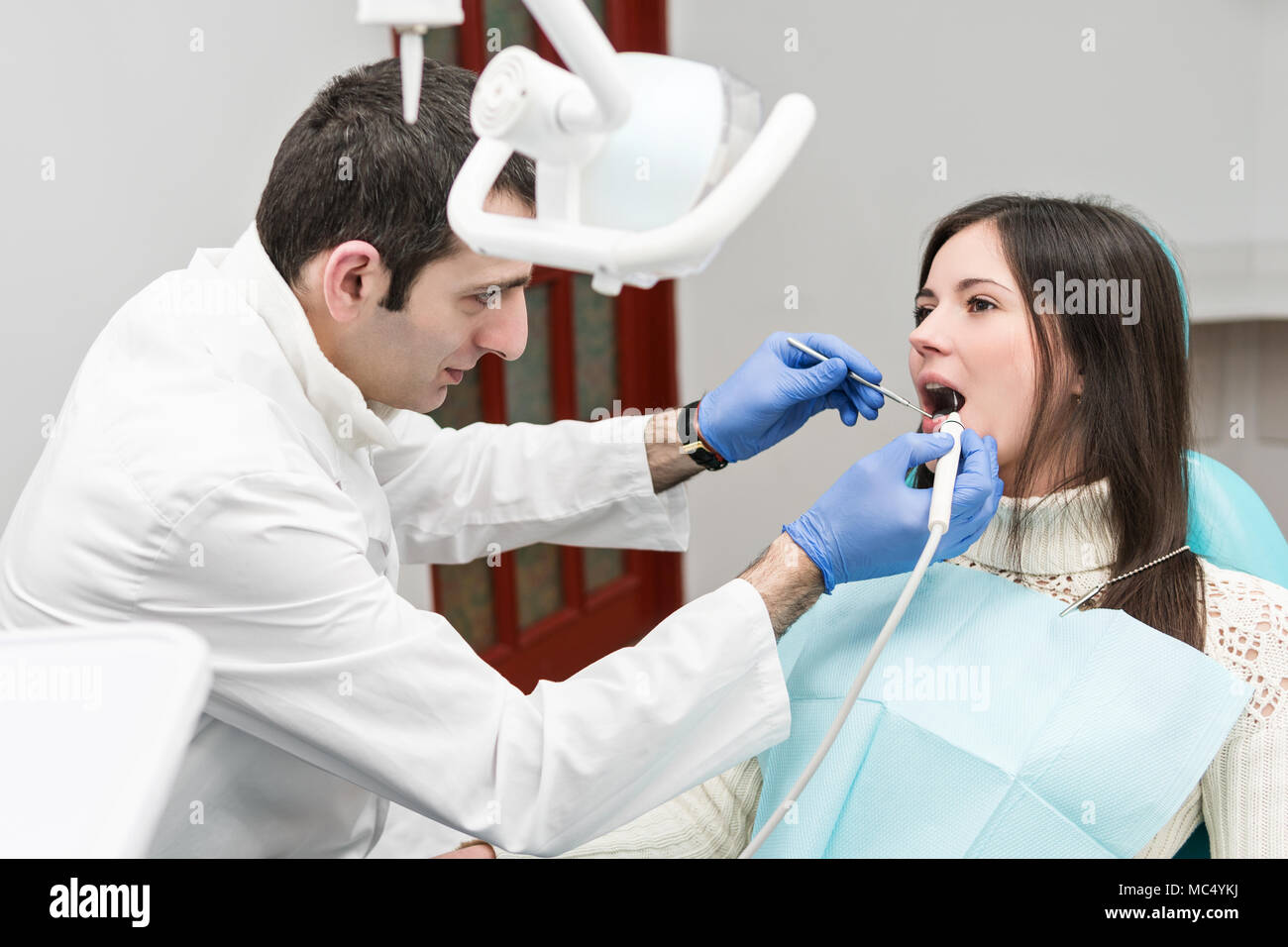 Ultraschall Reinigung der Zähne mit Wasserdruck bei einem Patienten Frau, sitzen in den zahnmedizinischen Stuhl Stockfoto