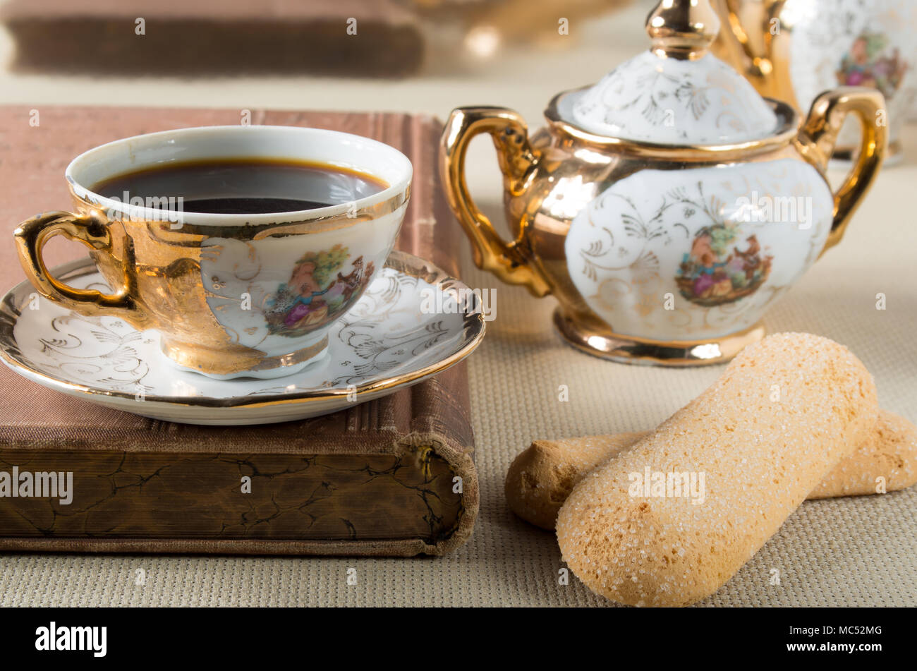 Espresso und Cookies Savoiardi auf einem Tisch mit einer Reihe von Vintage vergoldet Porzellan Geschirr aus dem 19. Jahrhundert Deutsche Bayern Stockfoto