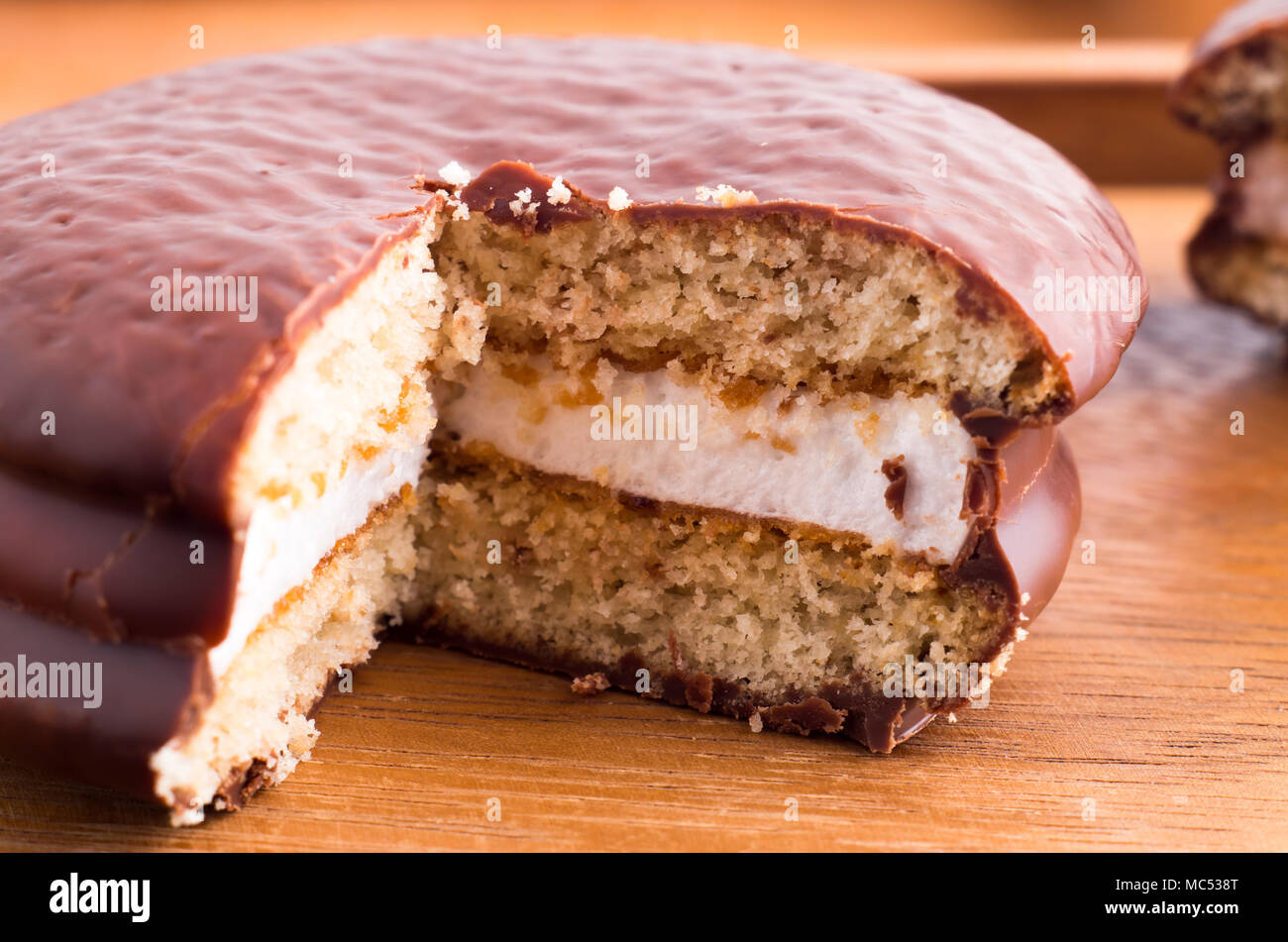 Keks mit Schokolade und eine Schicht von Milch souffle auf einer hölzernen Oberfläche closeup Stockfoto