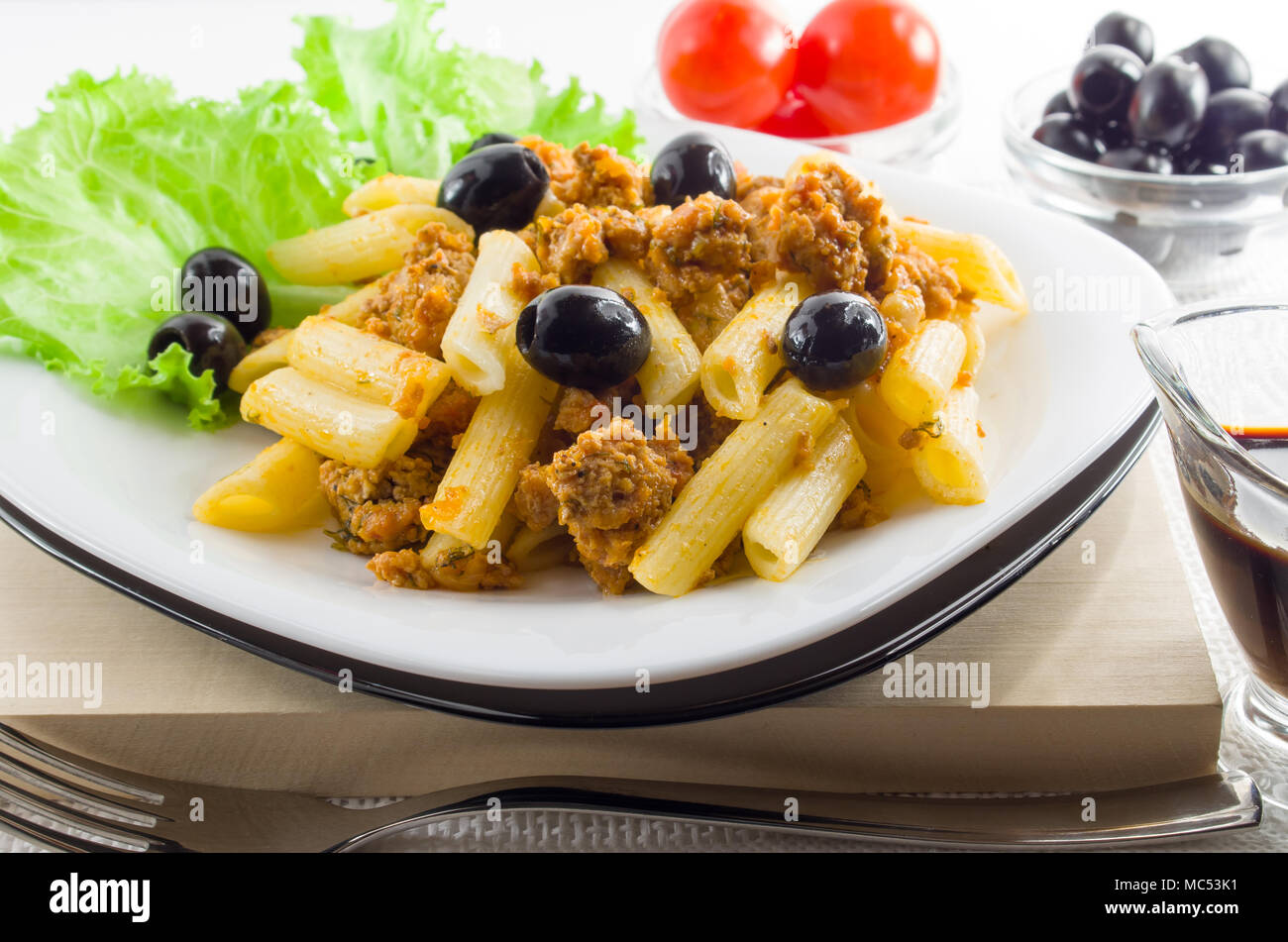 Italienische Pasta Penne mit Bolognese Sauce, Rindfleisch und Oliven auf einem weißen Teller closeup Stockfoto