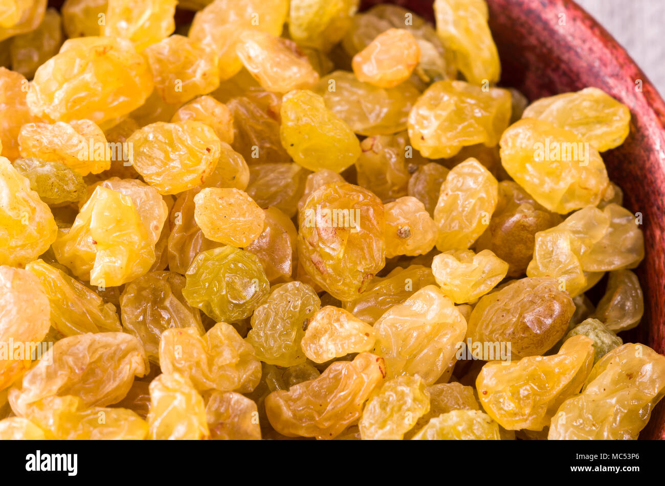 Süßen Rosinen in eine braune hölzerne Schüssel, close-up mit einer geringen Tiefenschärfe Stockfoto