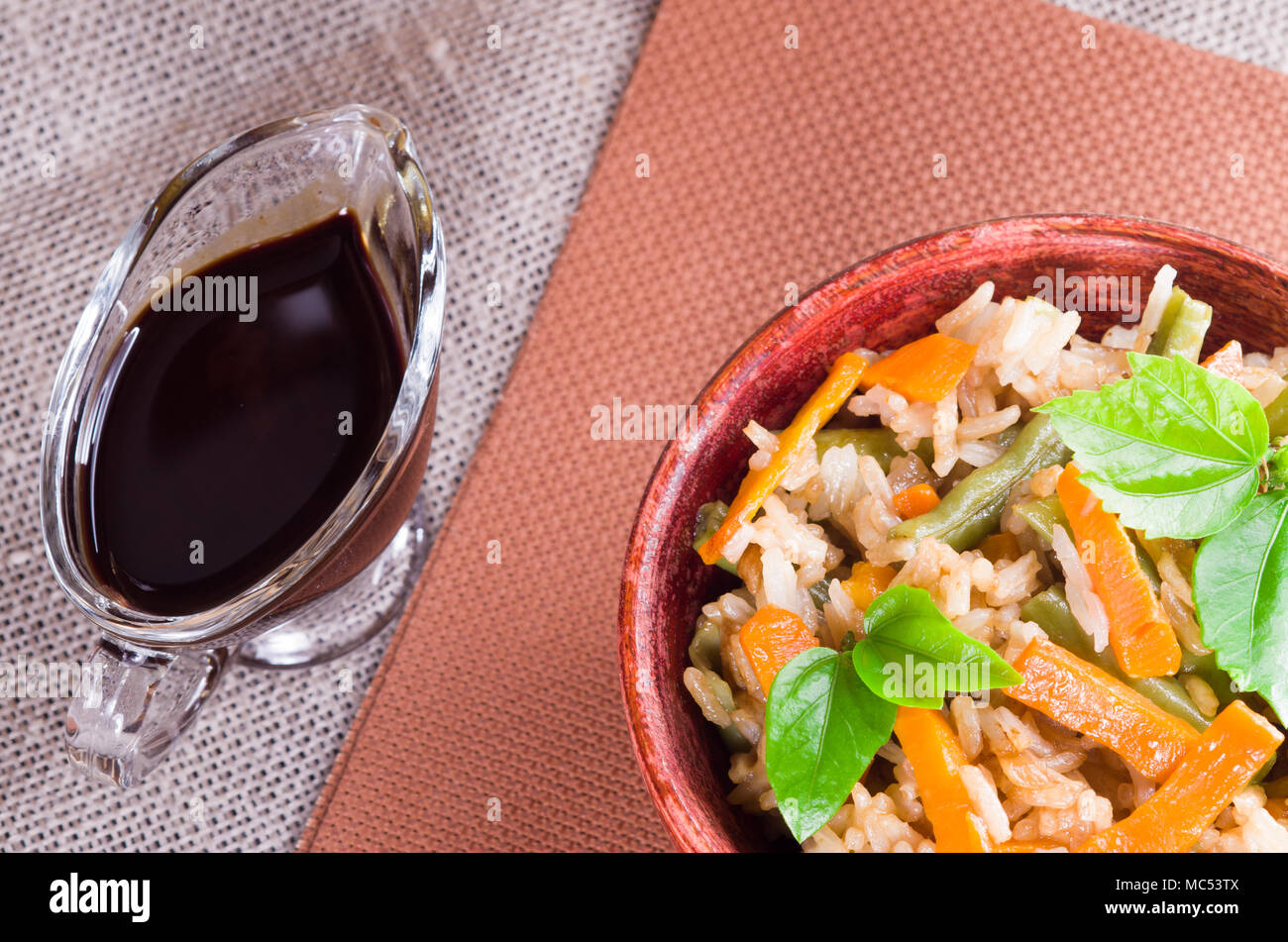 Ansicht von oben in eine Schale Reis, Möhren und Bohnen mit Kräutern und Sojasauce Stockfoto