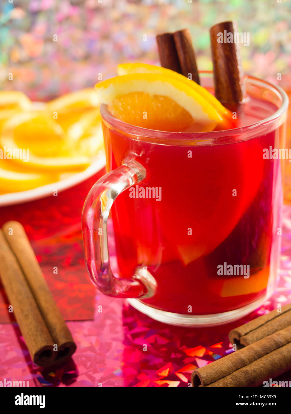 Transparente Teetasse mit Zitrusfrüchten, Zimt und Orange zu helle glänzende Hintergrund mit blur und flache Tiefenschärfe Stockfoto