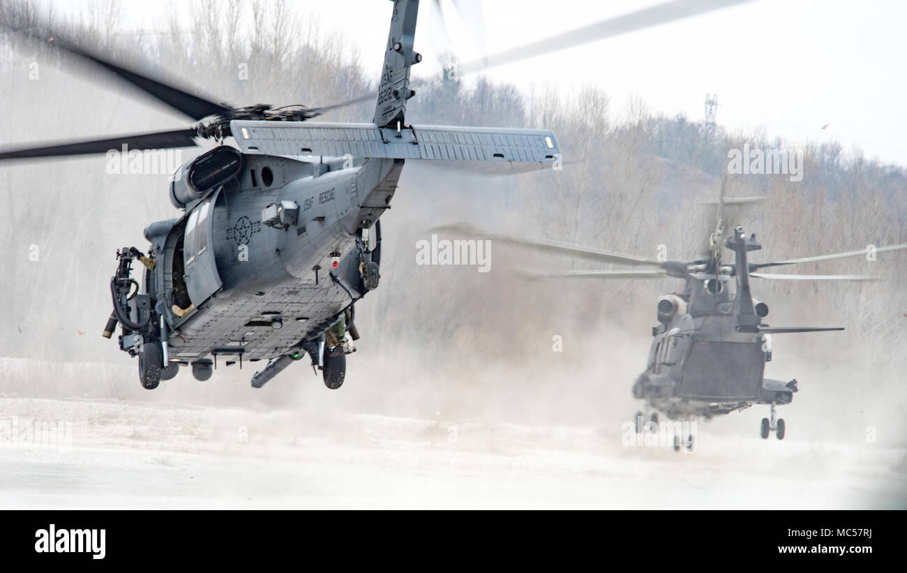 Ein HH-60G Pave Hawk Hubschrauber auf die 56Th Rescue Squadron landet mit einem italienischen HH-101 Caesar in der Nähe von Aviano Air Base, Italien zugewiesen, bei einer routinemäßigen Training Mission Jan. 26, 2018. Mitglieder aus der 56. und 57. RQS Fliegen in der gesamten Region während mehrerer unterschiedlicher Ausbildung Einsätze. Ihre Präsenz in der Fläche erhöht sich, da sie sich auf den Übergang von der Royal Air Force Base Lakenheath in England beginnen. Etwa 350 Mitarbeiter, fünf HH-60G Pave Hawk Hubschrauber werden voraussichtlich in einer Bemühung, eine dauerhafte Personal Recovery Standort innerhalb Europas zu etablieren Aviano AB zu verlagern. (U.S. Air F Stockfoto