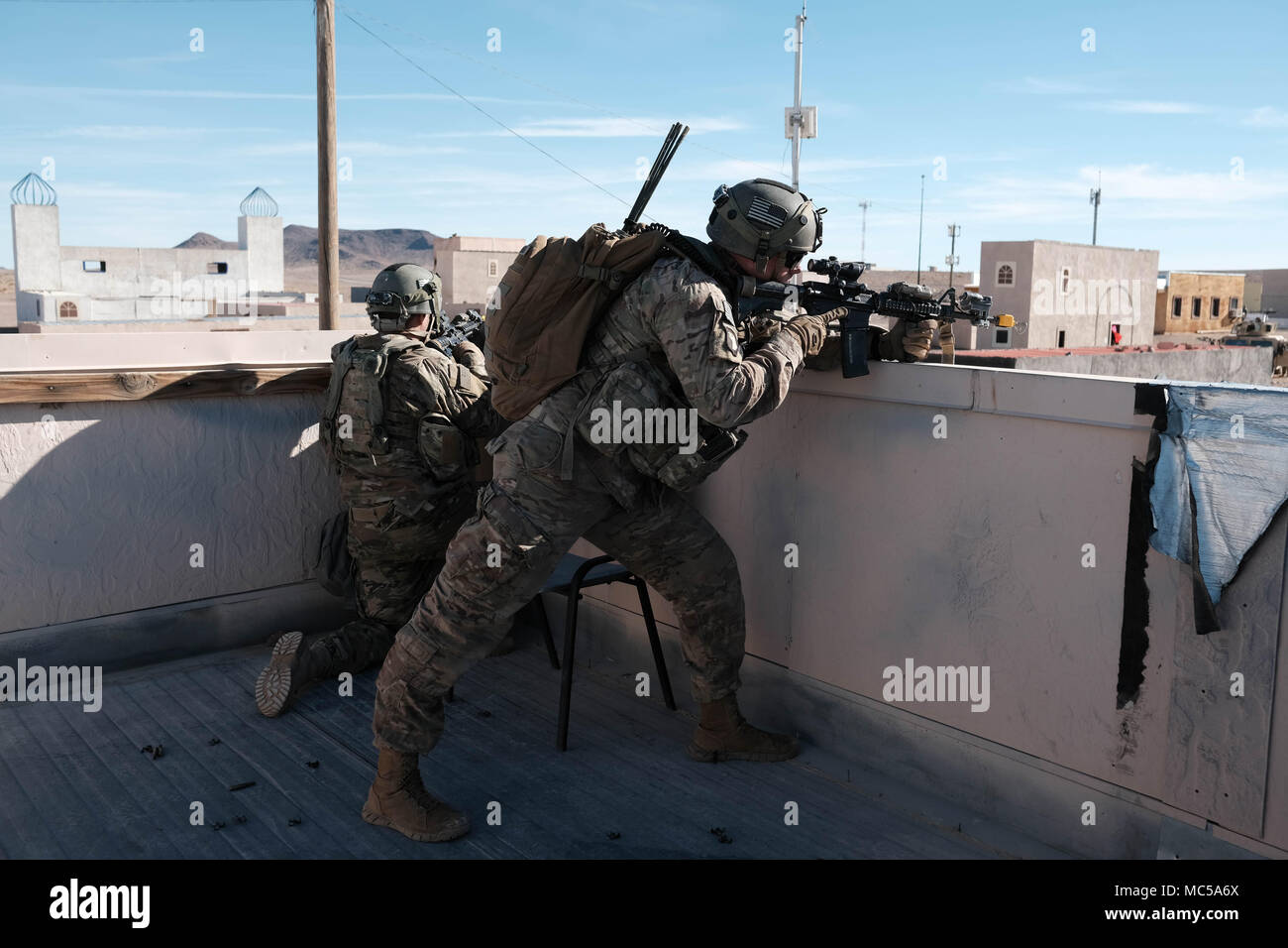 Staff Sgt. Craig Spangler und seine Mannschaft über Watch als freundliche Kräfte Manöver die Straße unten während der entscheidenden Aktion Rotation 18-03 am National Training Center, 31.01.19. Die Ausbildung ist eine Widerspiegelung der Komplexität der potentielle Gegner unserer Nation gegenüberstellen könnte und beinhalten: Guerilla, die Aufständischen, Kriminellen und in der Nähe von-Peer konventionelle Streitkräfte in einem dynamischen Umfeld verwoben. (U.S. Armee Foto von SPC. Jorge Calzadilla, 1 SBCT, Öffentliche Angelegenheiten) Stockfoto