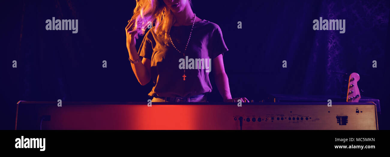 Weibliche Musiker Klavier spielen im Nachtclub Stockfoto