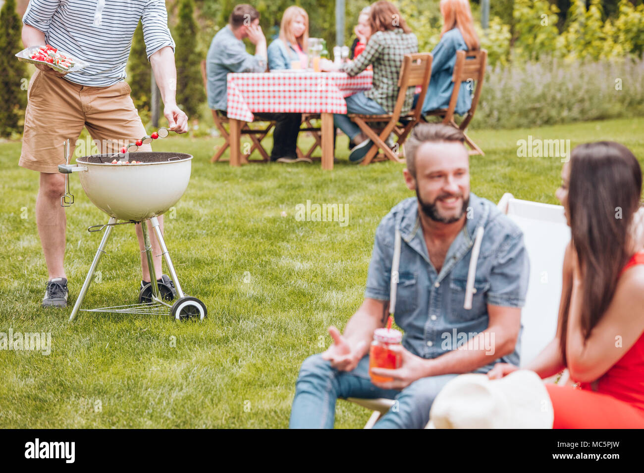 Man grillen shashliks während der Grillparty mit Freunden im Garten Stockfoto