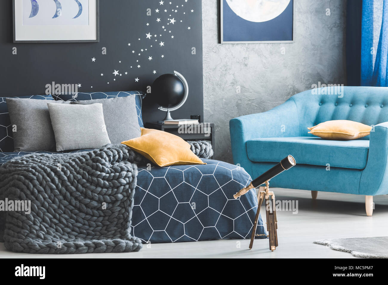 Close-up von Teleskop und gelben Kissen im offenen Raum Interieur mit grauen Decke und blaue Sessel Stockfoto