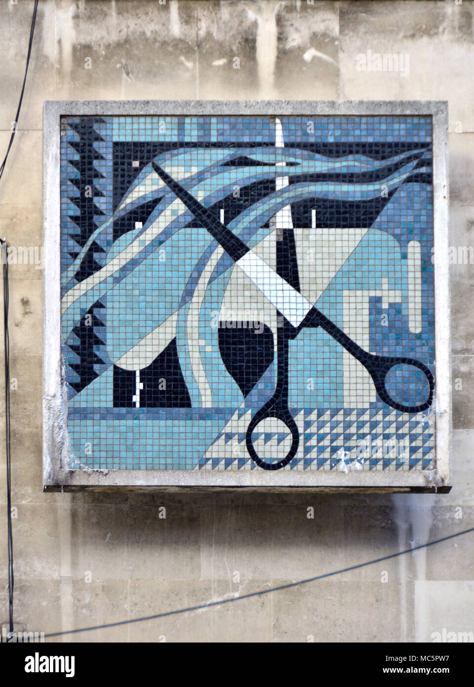 London, England, UK. London College Mode, John Prince's Street/Oxford Street. Detail der Fassade - Mosaik von Schere und Nähmaschine Stockfoto