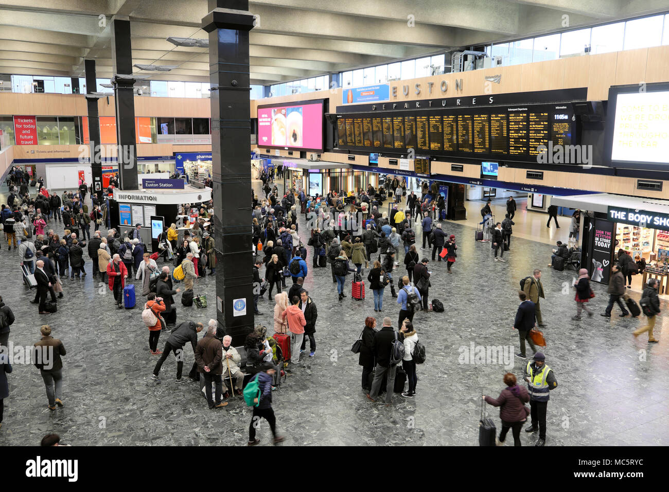 Reisende stehend, wartend auf die bahnhofshalle in der Anzeigetafel auf der Euston Station in London, England, UK KATHY DEWITT Stockfoto