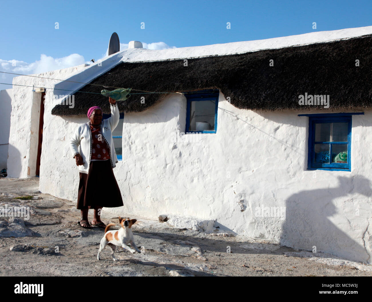 Fisherman's Frau hängt Wäsche in der Kassiesbaai, Fischerdorf in Armiston, Südafrika Stockfoto