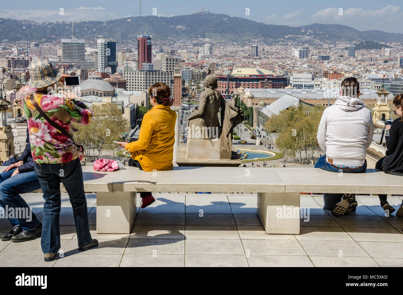 Ein Blick von außen das nationale Kunstmuseum von Katalonien über die Stadt Barcelona. Touristen sitzen auf einer Bank, um die Aussicht zu genießen. Stockfoto