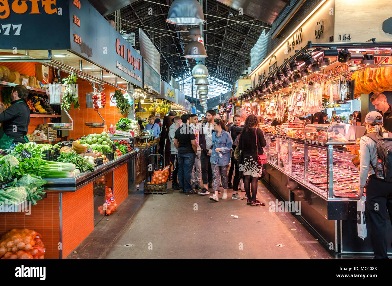 Ein Blick in geschlossenen öffentlichen Markt La Boqueria in Barcelona, Spanien. Auf der einen Seite des Ganges ist ein Delikatessen und auf der anderen ein Obst- und Gemüsehändler. Stockfoto