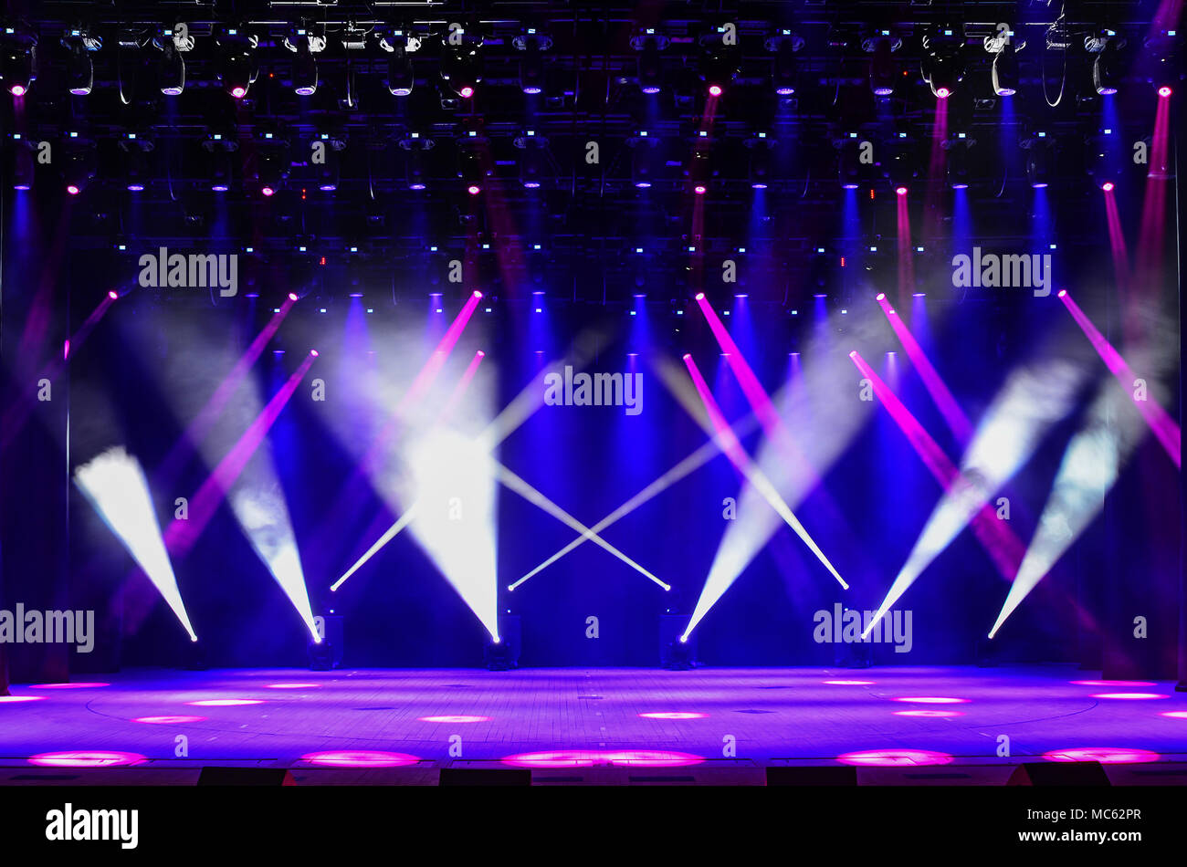 Beleuchtete leere Bühne mit Dunst und Strahlen von Rot, Violett und Blau. Hintergrund für die Musik zeigen Stockfoto