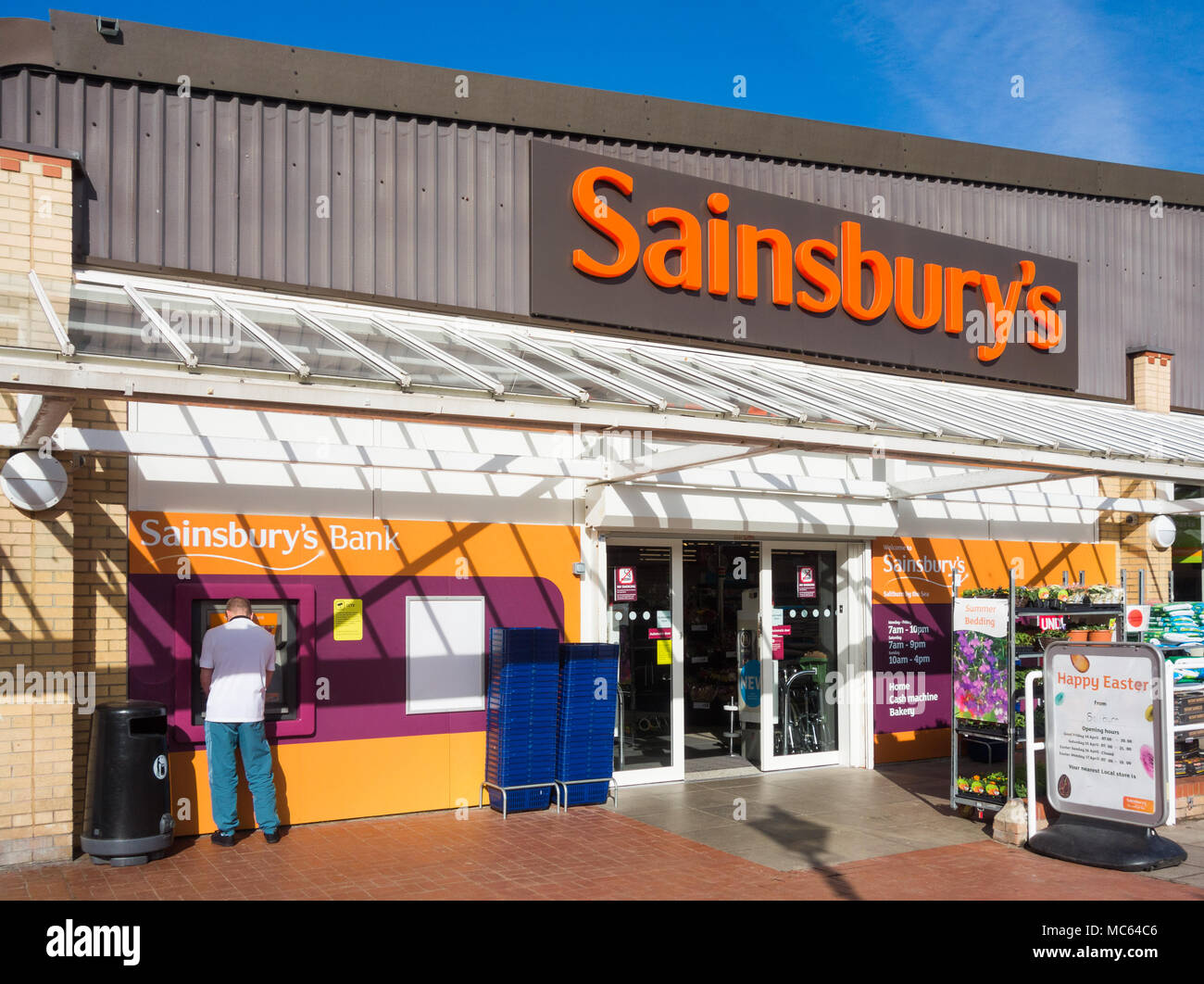 Mann mit Bargeld Maschine außerhalb Sainsbury's Supermarkt. England. Großbritannien Stockfoto