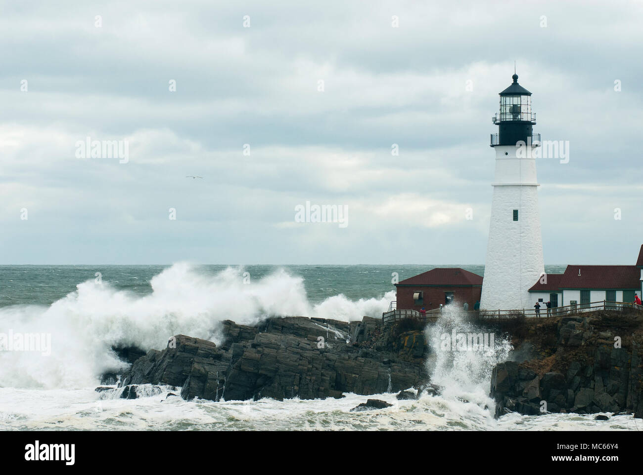 Selten astronomisch hohen Gezeiten verursachen riesige Wellen durch Portland Head Lighthouse in Maine zu brechen. Stockfoto