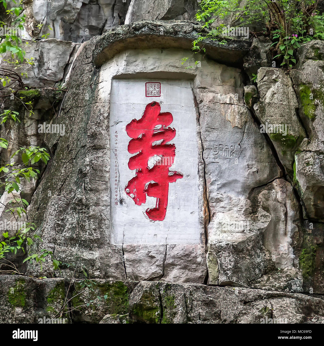 Eine Inschrift und steinbildhauerei an der Basis der einsame Schönheit Peak, Guilin, China. Die rot lackierten Chinesische Zeichen ist Shou, die Langlebigkeit bedeutet. Stockfoto