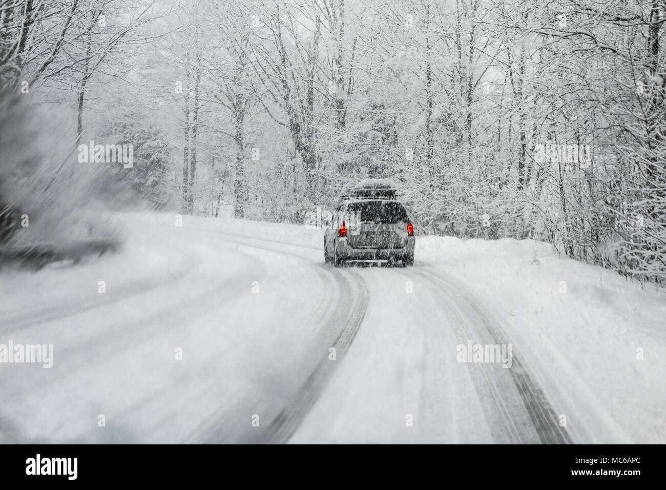 Autofahren im Winter Schnee durch eine Windschutzscheibe mit blured Schneeflocken fallen. Stockfoto