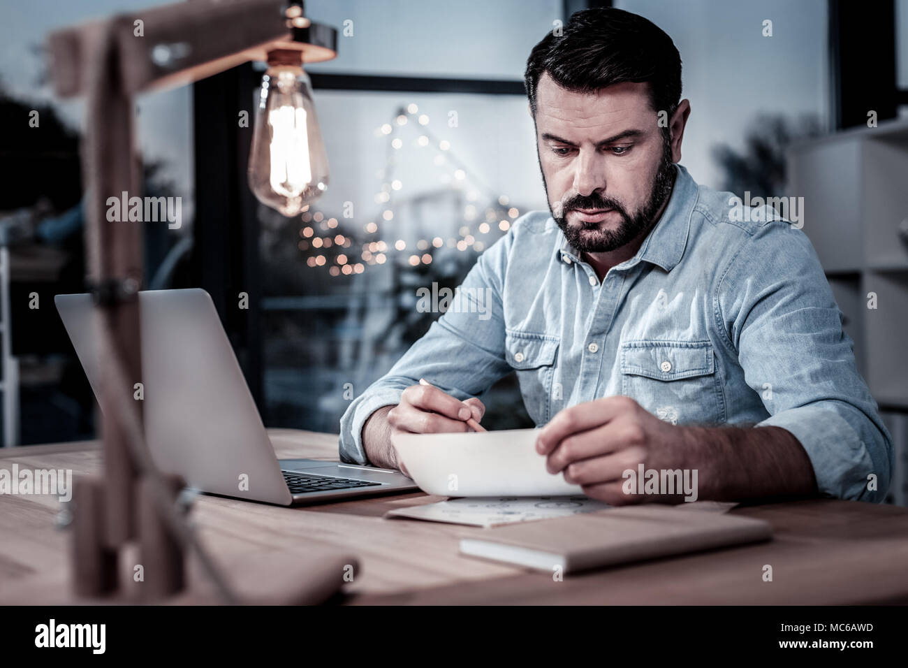 Ernsthafte unshaken Mann sitzt und sich auf das Schreiben. Stockfoto