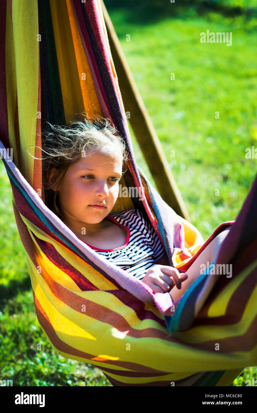 Kind, Mädchen, das sich in einem sonnigen Hängematte auf Urlaub. Stockfoto