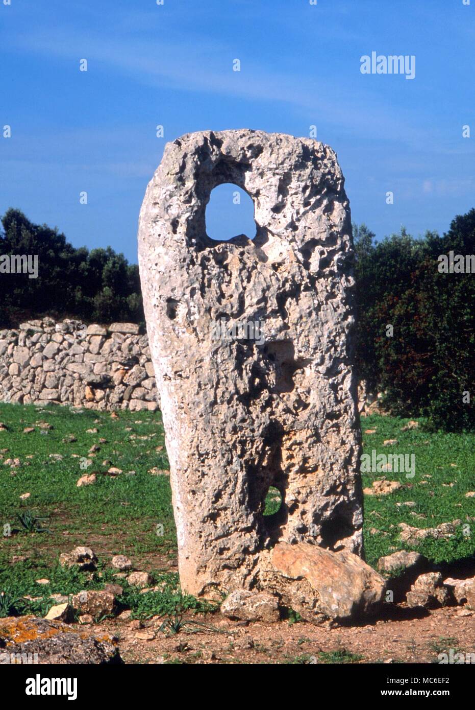 Steine - das "Bullauge" eines durchlöchert, Stein, eindeutig als eine Sichtung Linie eingesetzt, in der Nähe der Taula auf der Website der Talati de Dalt, Menorca. Den Sonnenaufgang und Mondaufgang kann von einem Aussichtspunkt angesehen werden nur ein paar Meter nach Westen Stockfoto